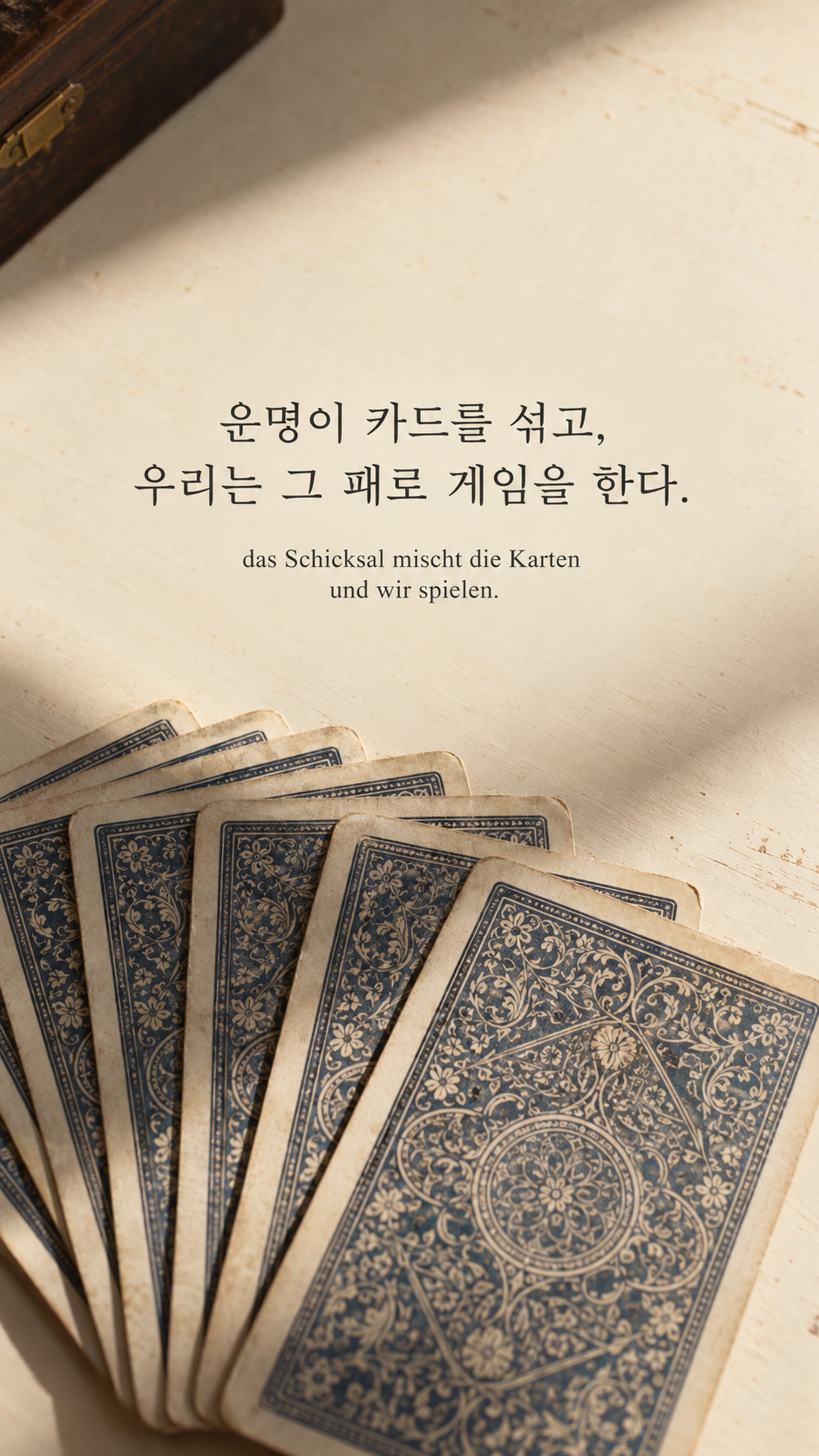 쇼펜하우어 명언 27 운명이 카드를 섞고, 우리는 그 패로 게임을 한다. 밝은 테이블 위 펼쳐진 카드 뒷면 배경의 한글&middot;독일어 이미지