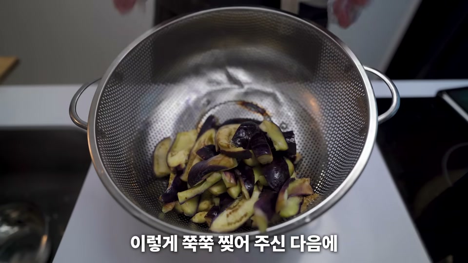 찐 가지를 손으로 찢는 장면