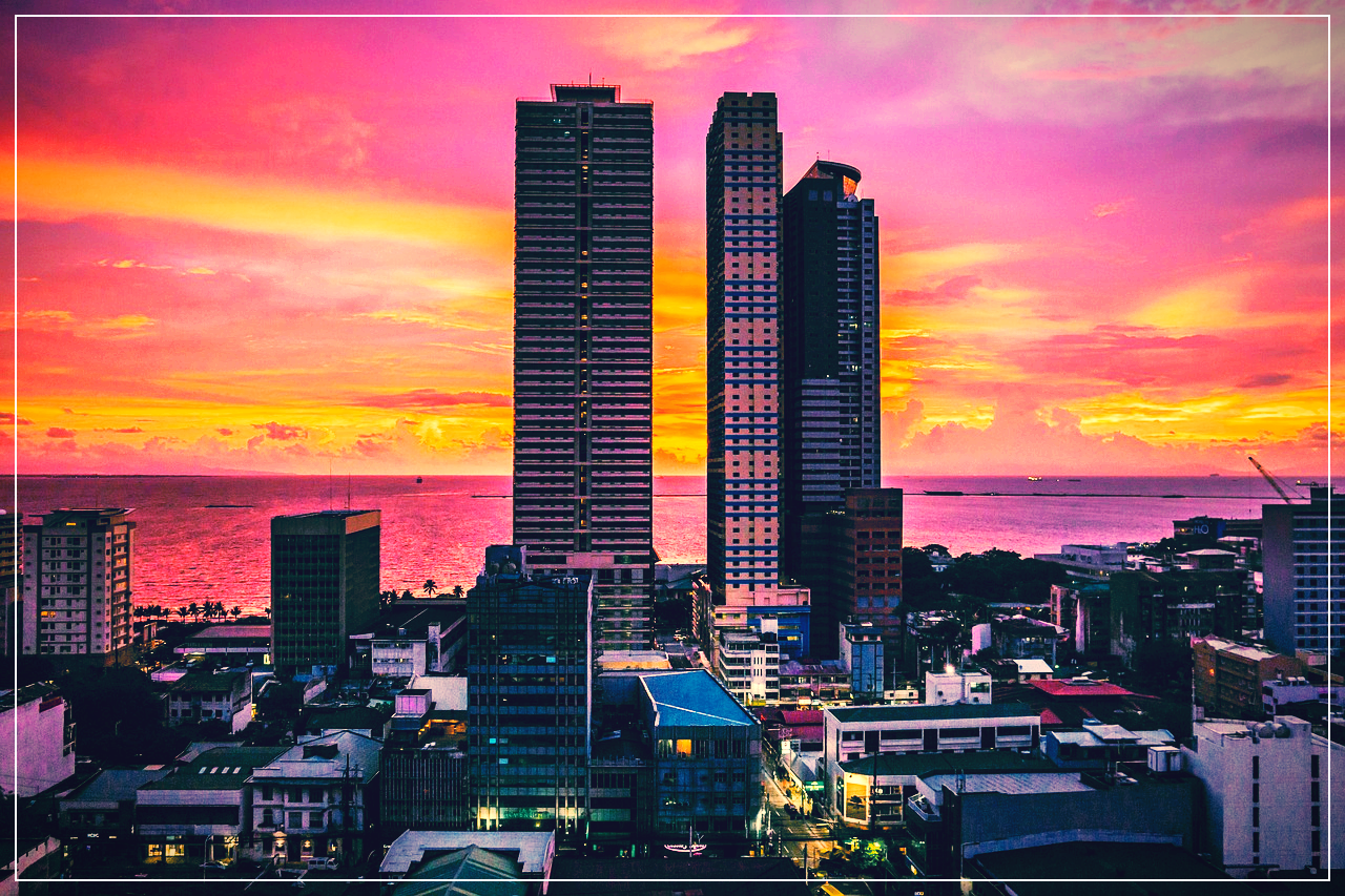 마닐라의 석양이 지는 모습. 고층빌딩과 바다가 보인다.