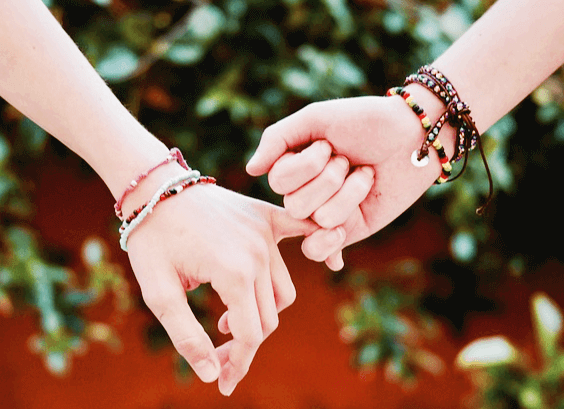 두 사람의 새끼 손가락을 걸고 있다. 팔에는 팔찌들이 있다.