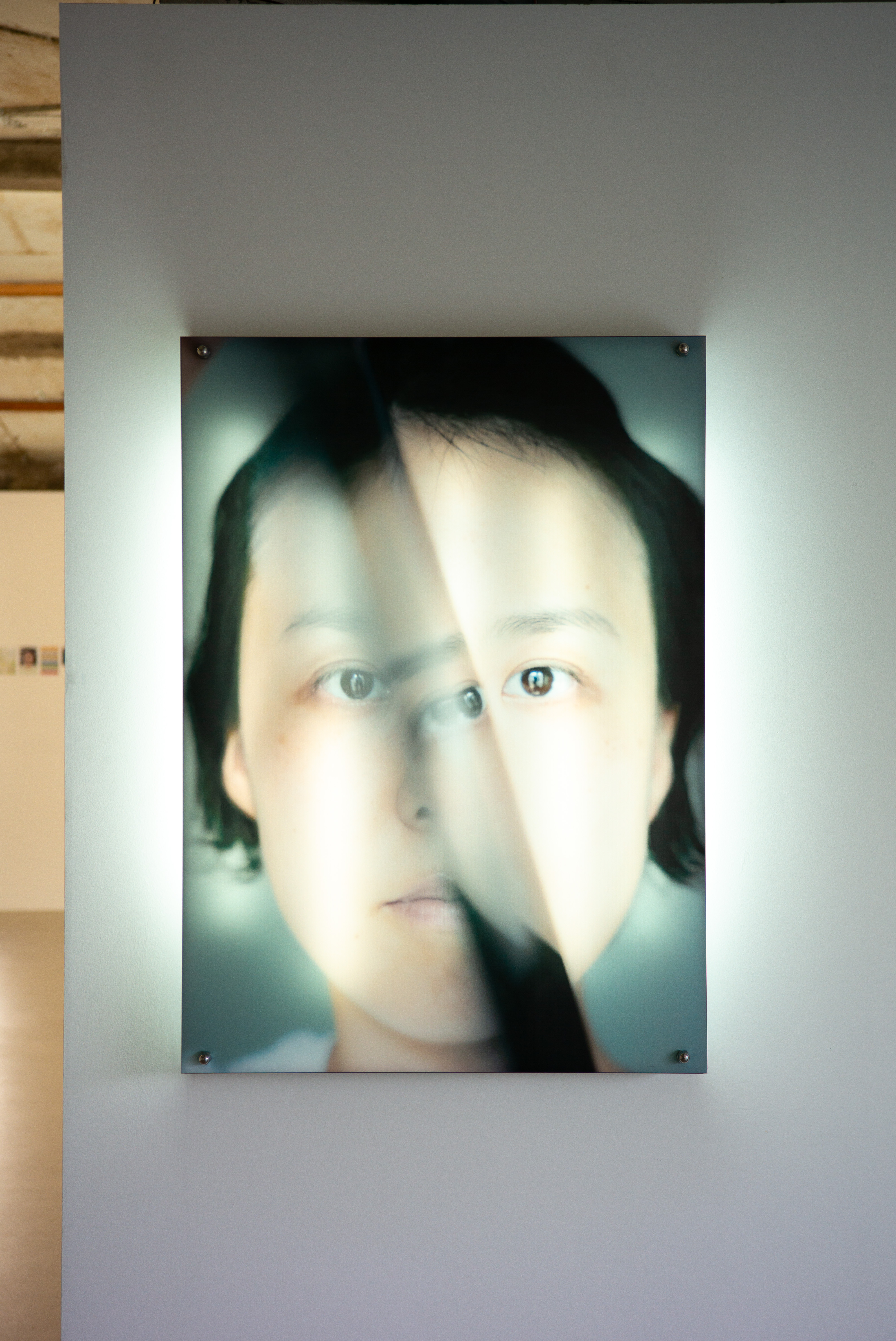 라이카 M-P 240으로 촬영한 전시회 내부 사진. 조명이 들어온 몽환적인 인물 포트레이트 작품이 화이트 월에 걸려 있는 모습.