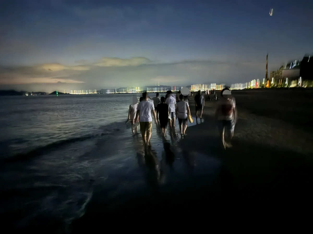 맨발로 해안가를 걷고 있는 사람들