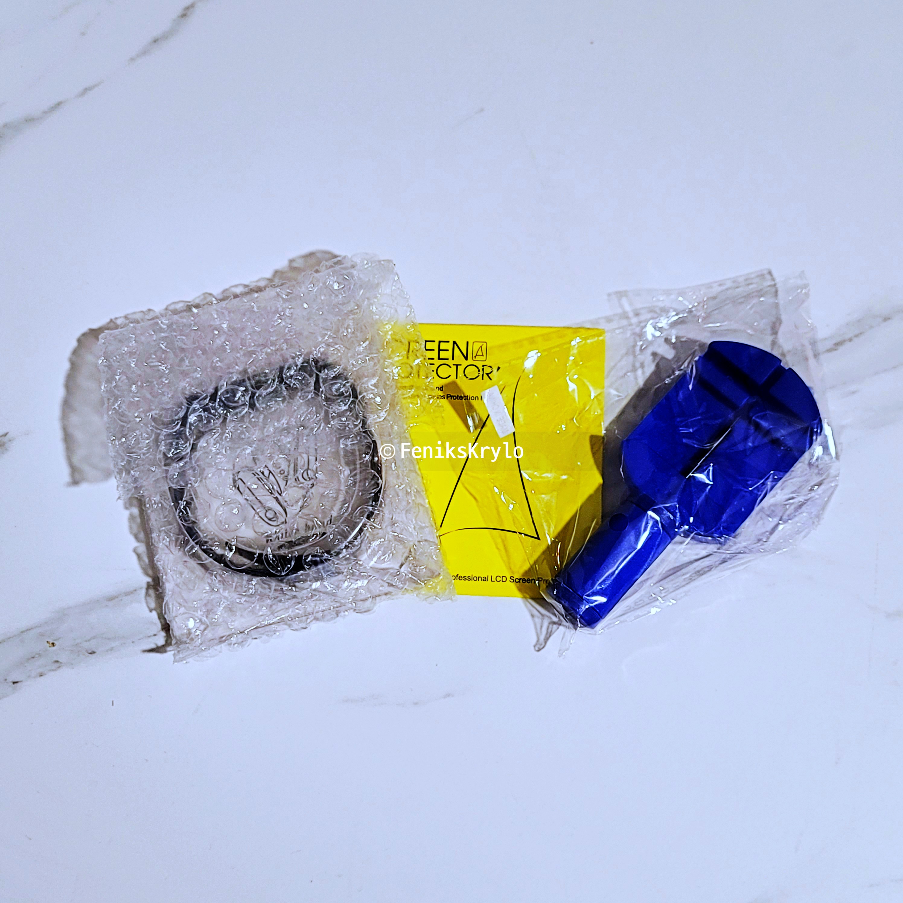 갤럭시-핏2-스트랩과-사은품들이-테이블-위에-놓여있다.