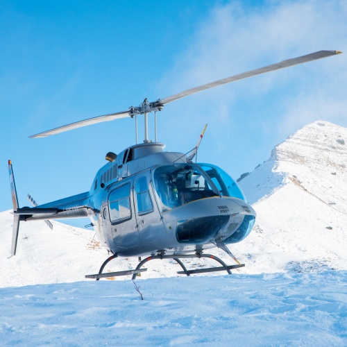 Helicopter flying over snow-capped mountains