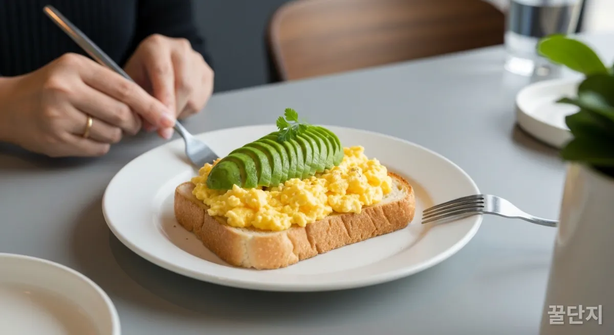 스크램블 에그와 아보카도 토스트가 담긴 접시