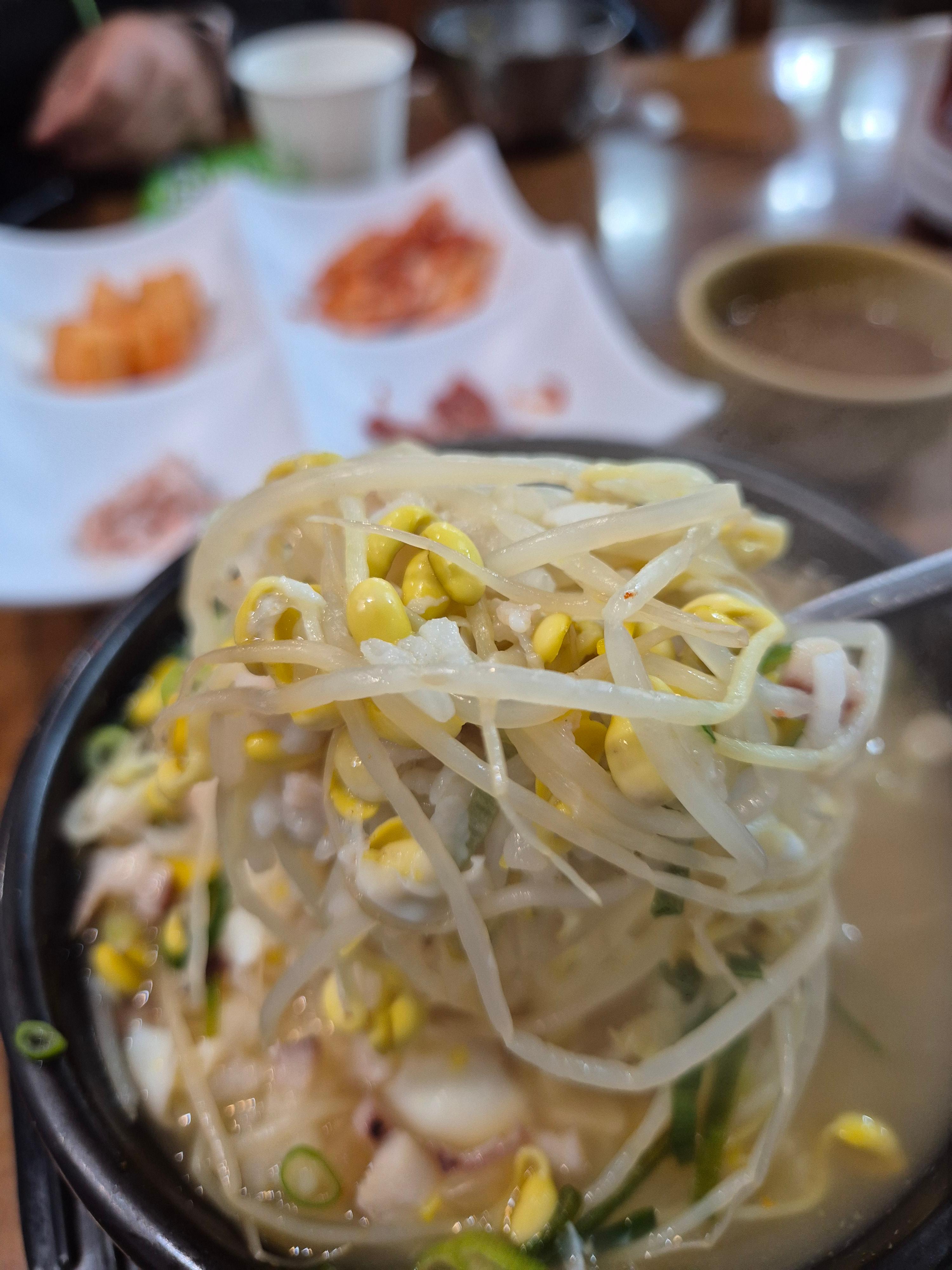 콩나물과 파가 올라간 전주 왱이콩나물국밥을 가까이 촬영한 모습