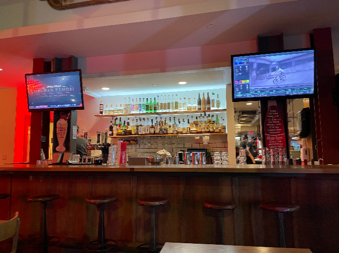 Cassell&amp;#39;s Hambergers 바의 모습. 다양한 종류의 위스키와 맥주가 진열되어 있다. 바의 양쪽 위로는 작은 tv가 걸려 있다. 