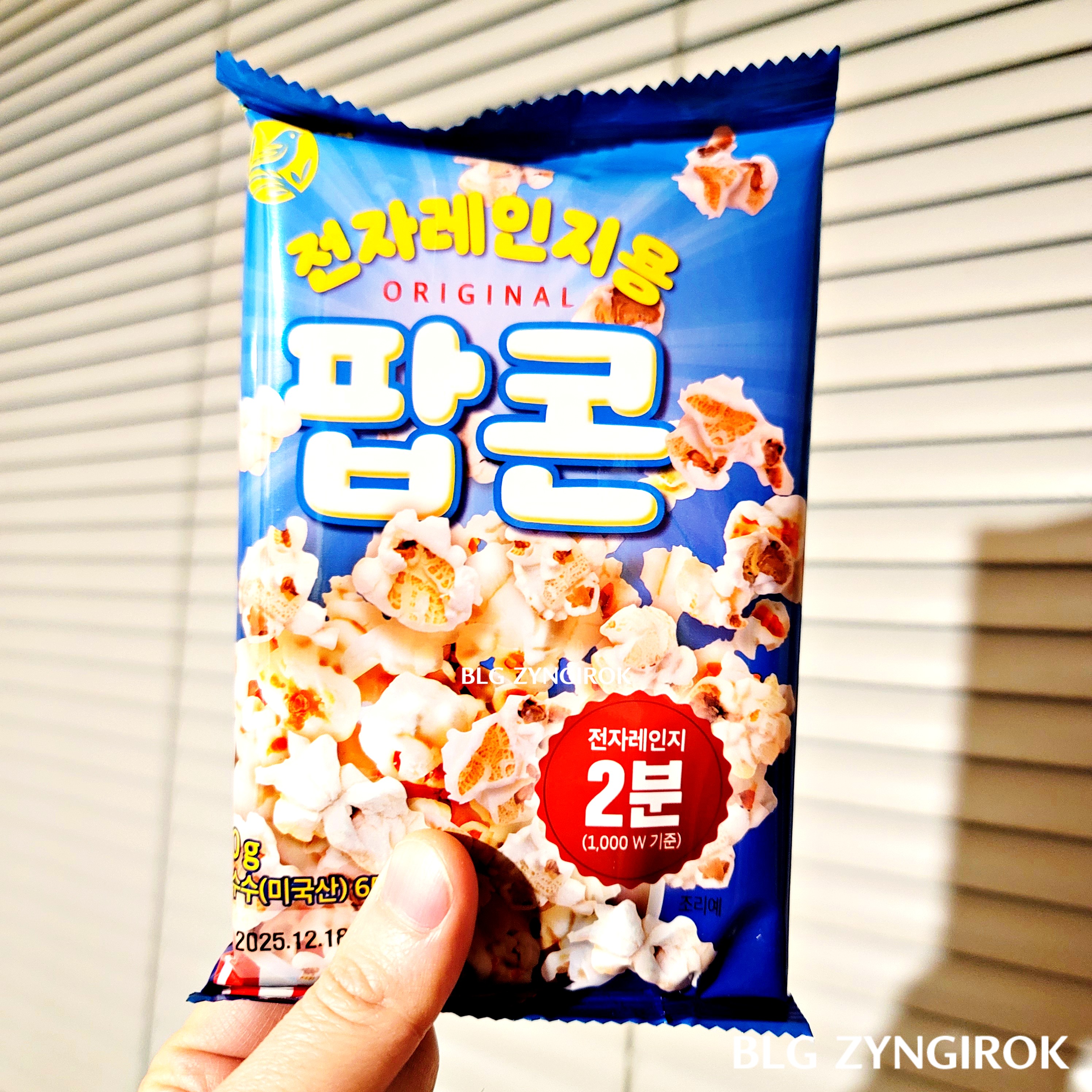 노브랜드 팝콘 봉지를 들고 있다.