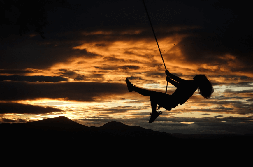 해질 무렵 그네를 타고 있는 사람