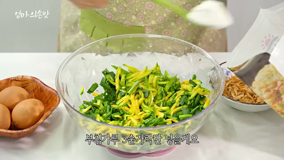 볼에 재료를 담고 부침가루를 넣는 장면