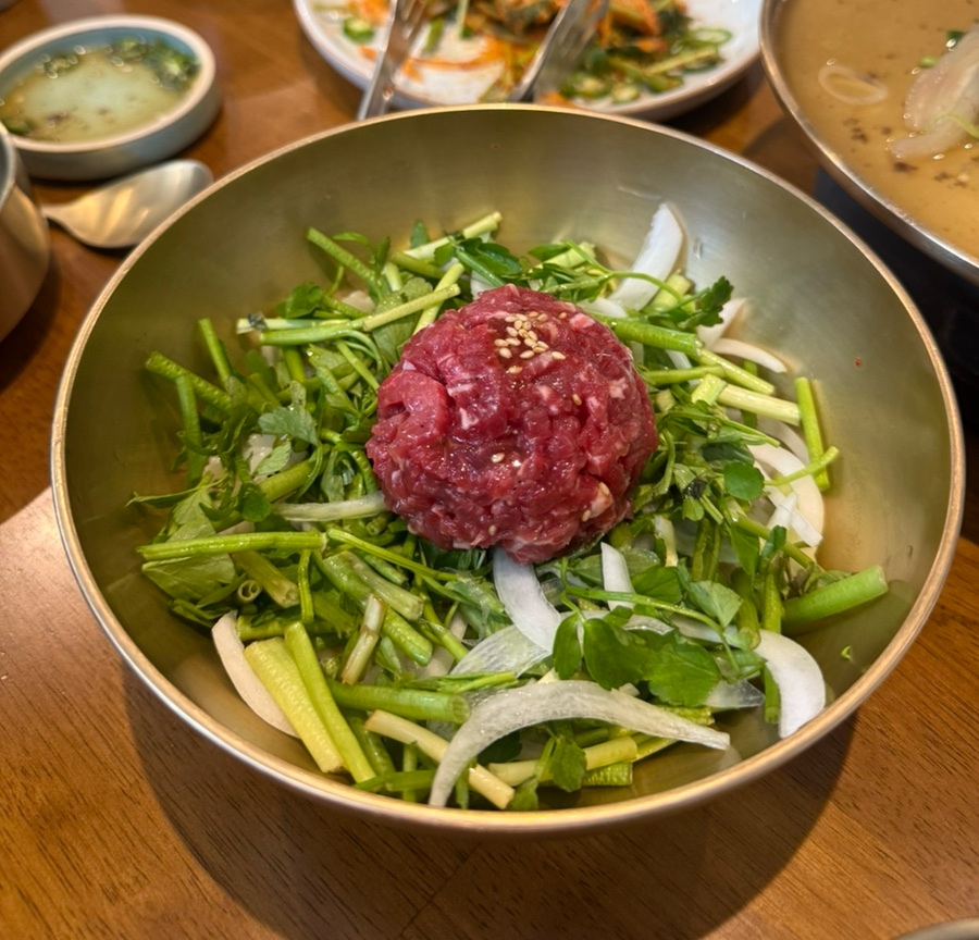 선홍빛 한우 육회와 신선한 채소의 육회비빔밥