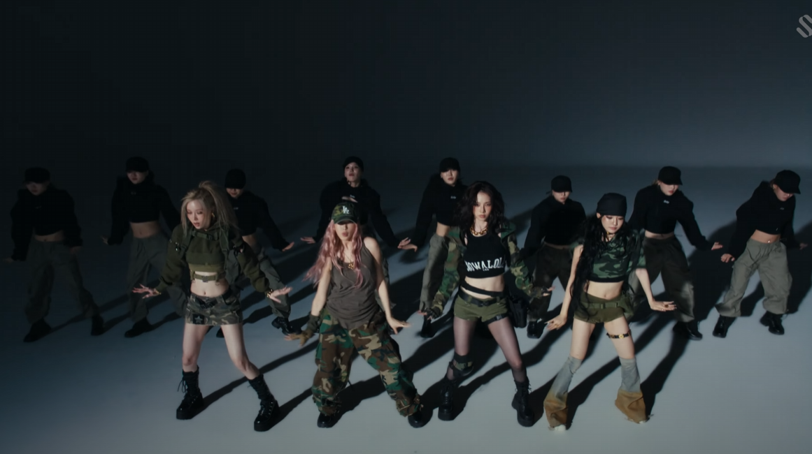 에스파 뮤직비디오의 한 장면.
멤버들과 댄서들이 일렬로 서 있다.