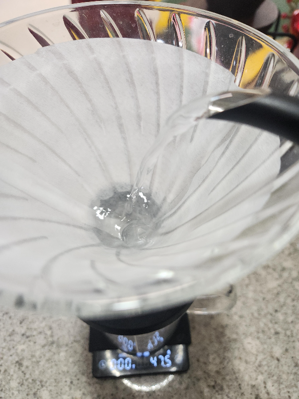 드리퍼에 50g의 물을 넣는 모습. 저울이 47.5g을 가르키고 있다.