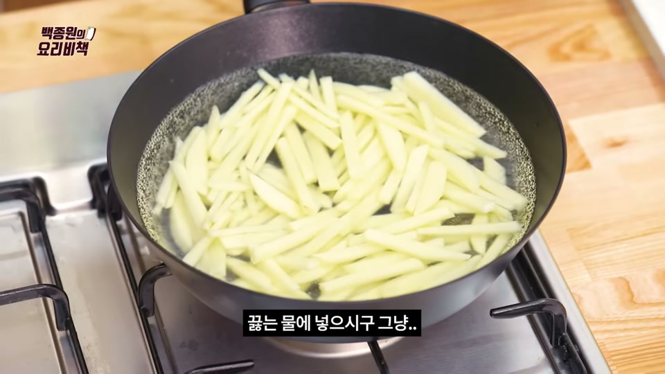 끓는 물에 감자채를 넣고 데치는 장면