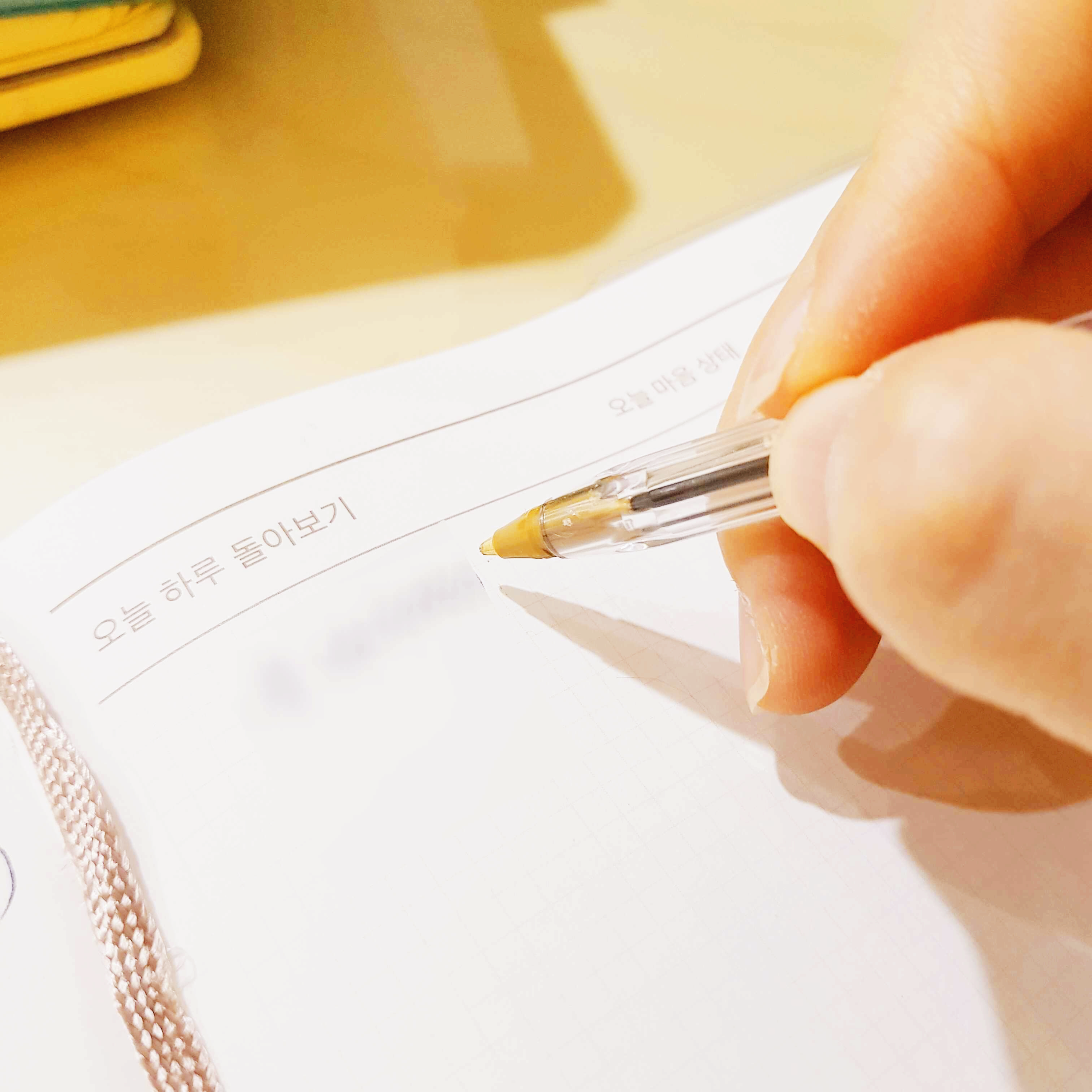 오늘 하루 돌아본 점을 리메이크 다이어리에 쓰는 모습