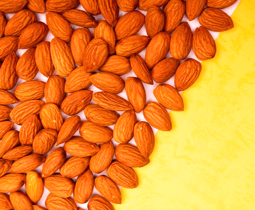 종이 위에 아몬드가 가득하다. 오른 쪽 여백은 노란색이다.
