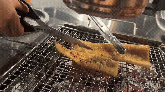 숯불 위에서 돼지껍데기를 가위로 자르며 굽는 장면 &mdash; 바삭하게 익어가는 모습이 보이는 GIF