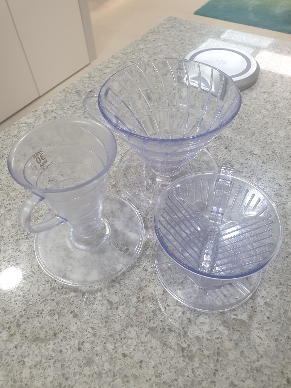 테이블 위에 하리오(상단), 타라치네(왼쪽)과 칼리타(우측 아래) 드리퍼가 놓여 있다.