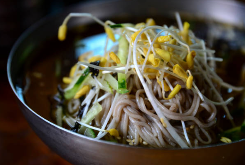 메밀 함량이 높은 메밀국수를 삶아 오이, 김, 메밀싹을 고명으로 올리고 동치미 육수를 부은 메밀 막국수