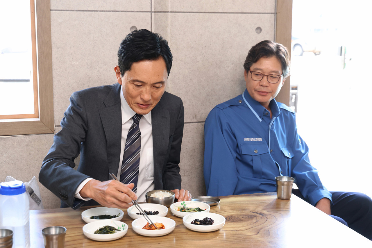 고독한 미식가 더 무비 주인공 고로상이 한국 직원과 함께 한국 식당에 앉아 있는 모습