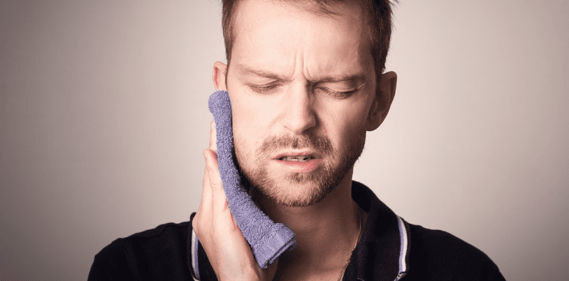 치통으로 차가운 수건을 볼에 대고 진정 시키고 있는 남자