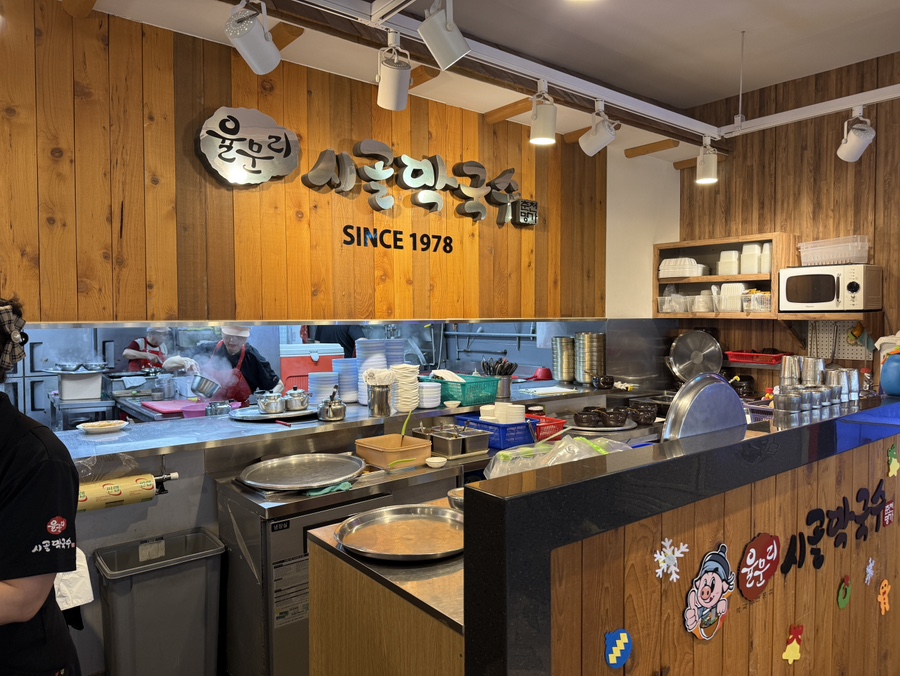 시골막국수 오픈주방 전경 사진, 조리 중인 직원과 조리대 포함