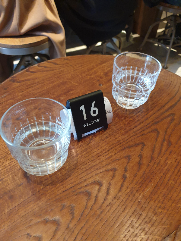 영수증과 대기표 그리고 물잔이 테이블 위에 있다.