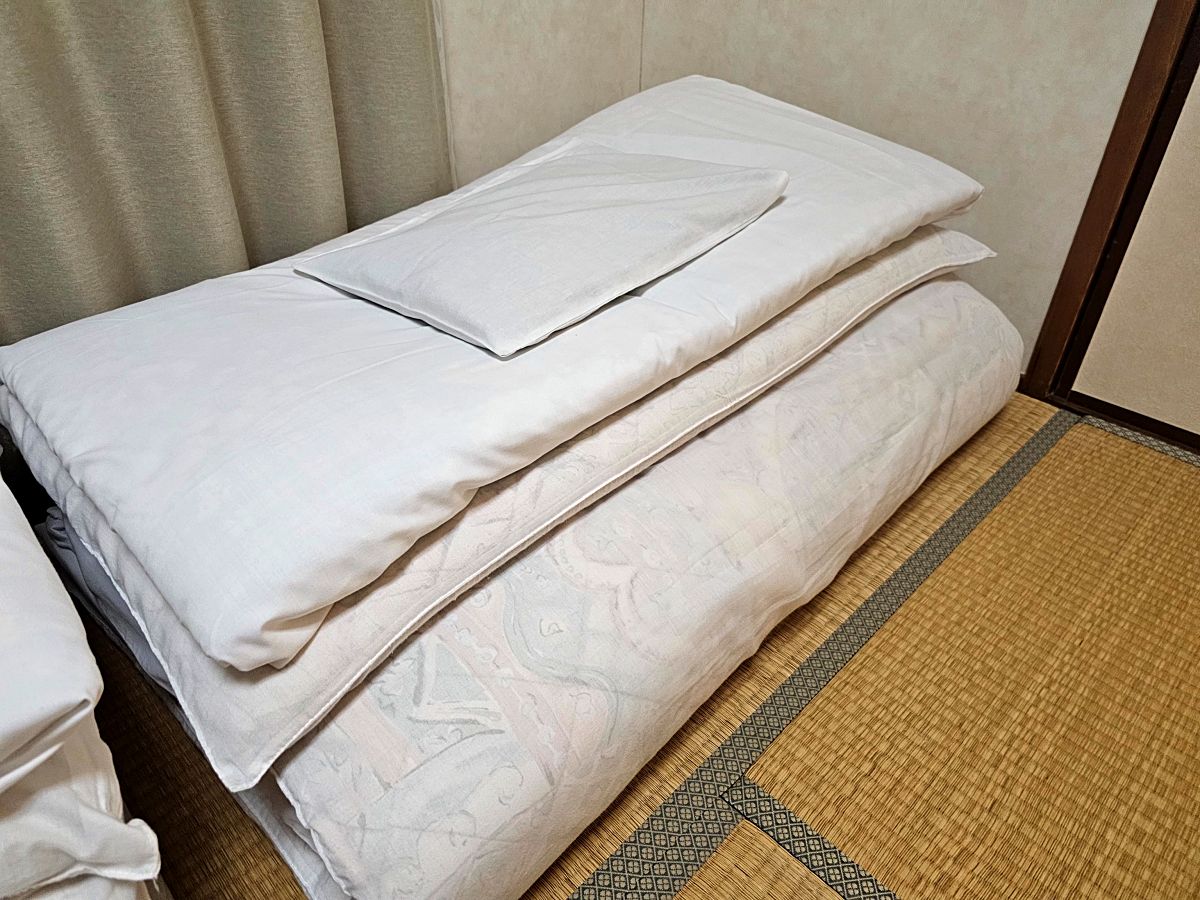 &ldquo;Traditional Japanese yofuton (folded futon) in Tamaki Ryokan room&rdquo;