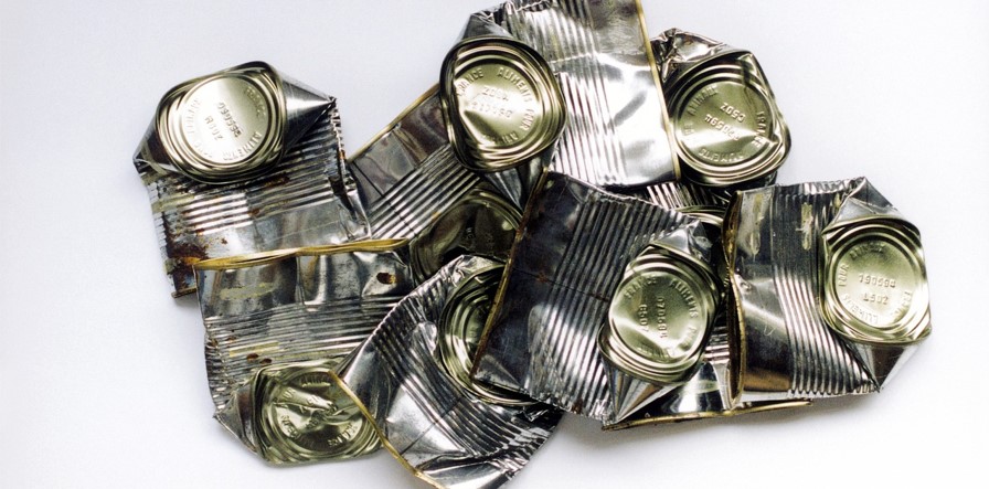 찌그러진 깡통들 여러개가 동그란 밑면과 윗면, 그리고 찌그러진 옆면을 보이며 아무렇게나 겹쳐져 있는 사진
