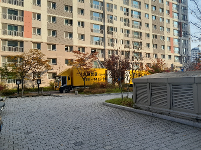 아파트에 정차 해 있는 노란색 이삿짐 차량과 사다리차