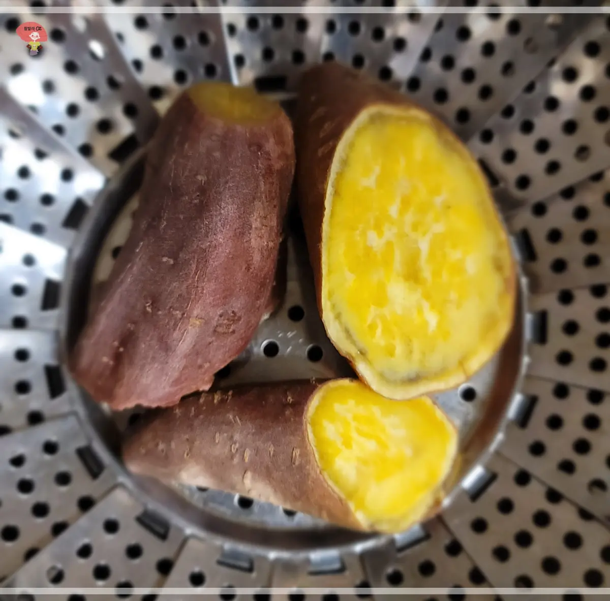 Three-pieces-of sweet-potato- one- cut- in- half -to-reveal-the -yellow-flesh-placed-in-a -stainless-steel- steamer-basket