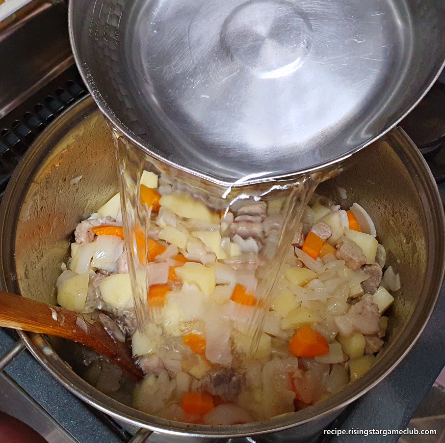 돼지고기 카레라이스에 들어갈 돼지고기와 야채 볶음에 뜨거운 물을 붓는 사진