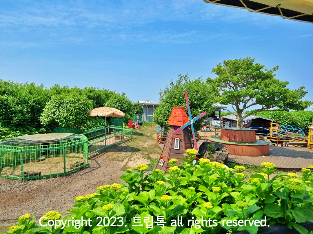 풍차와 그 주변에 동물우리가 보인다.