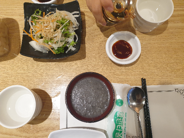 식전 흑임자죽과 양파 및 파 무침 그리고 식기가 제공되었다.