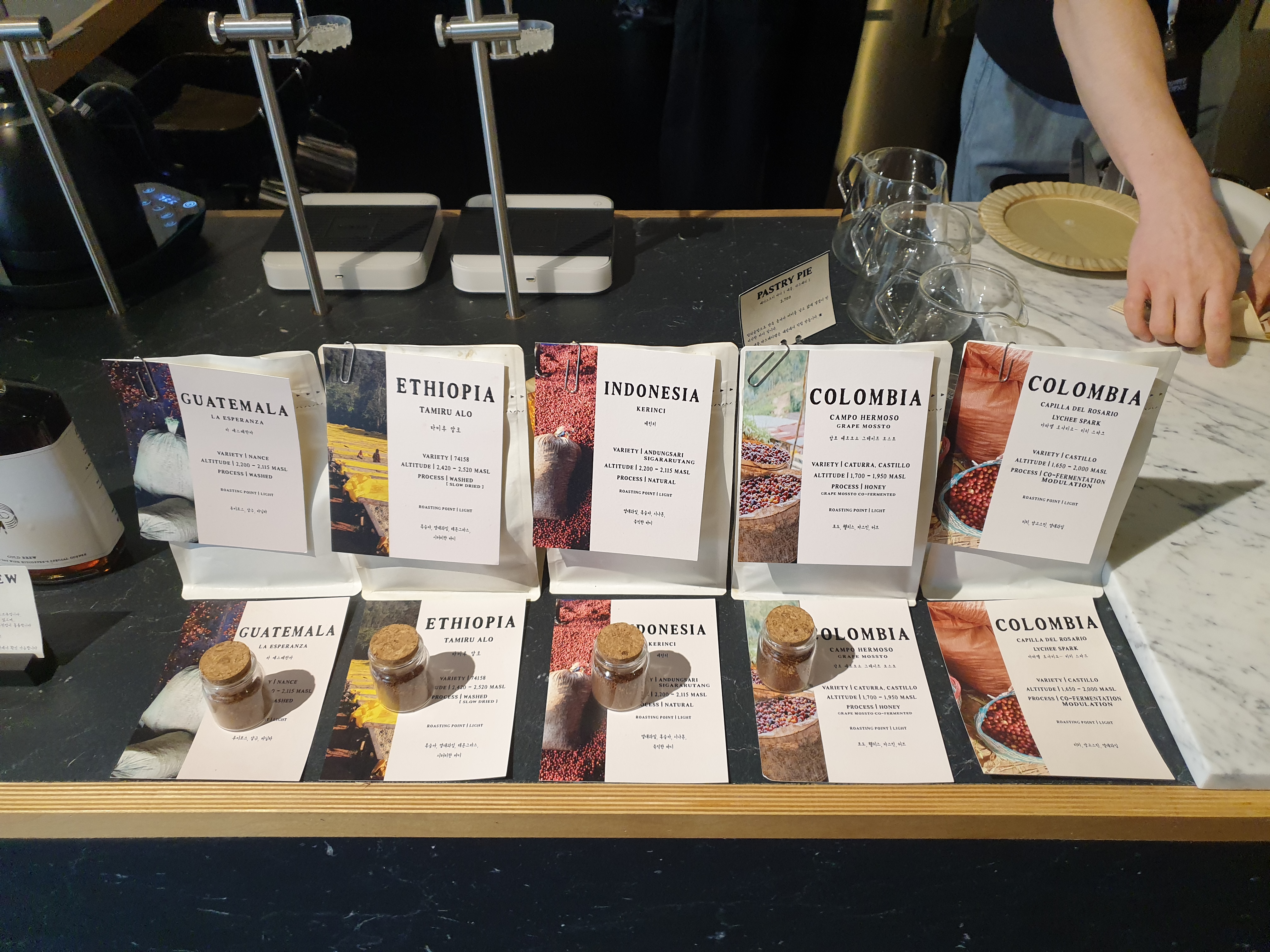 필터 커피 주문 가능한 판매용 원두 5종과 시향가능한 분쇄된 원두와 함께 진열되어 있다.