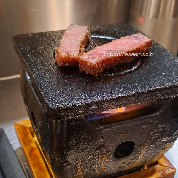 화로에 고기 2점이 놓여있어요.