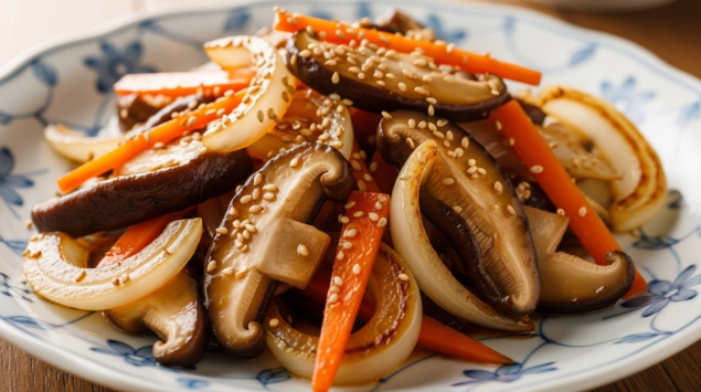 윤기가 흐르고 쫄깃해 보이는 새송이버섯 볶음이 예쁜 접시에 소복하게 담겨있다