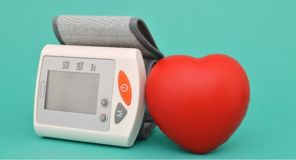 가정용 혈압계와 빨간 하트 모형 - 무더운 여름 혈압 관리의 중요성을 나타내는 이미지 via canva