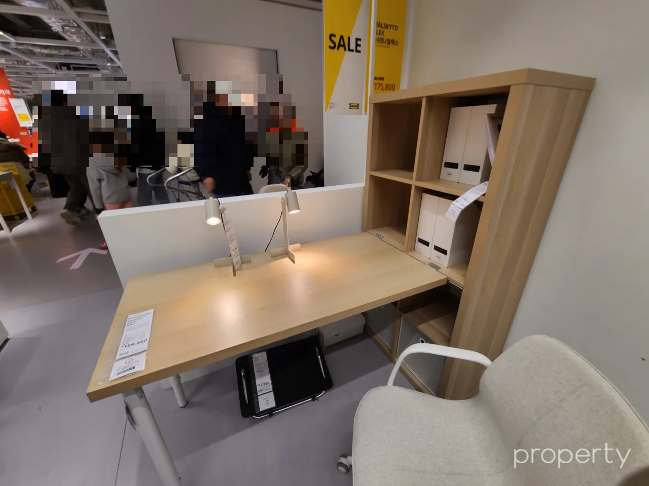 이케아매장-나무색책상-책상과책장이연결된모양-책상위에스텐드2개-책장에는흰색파일꽂이가꽂힌-책상아래검은색발판