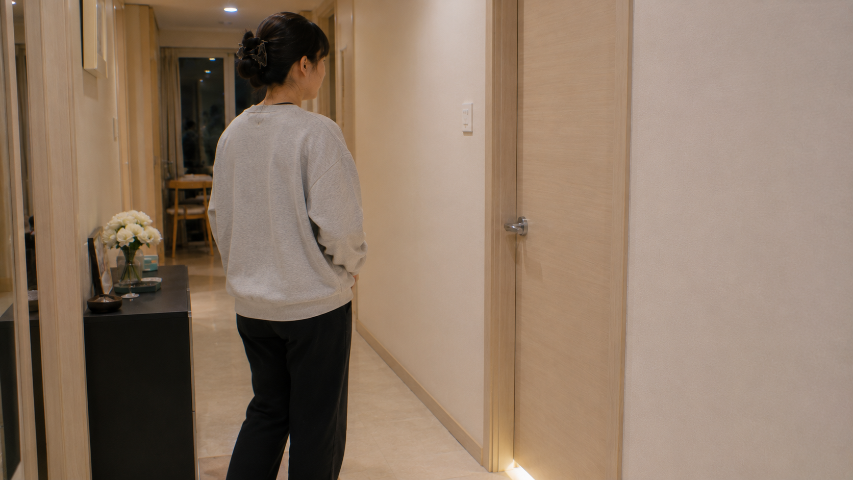 복도에서 아이 방을 바라보는 엄마
