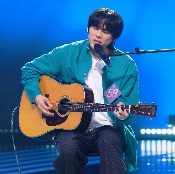 마이크앞에서-기타를치고-노래하는남성의모습