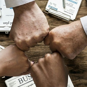 네 사람의 주먹이 한데 모여 마주 대고 있는 사진