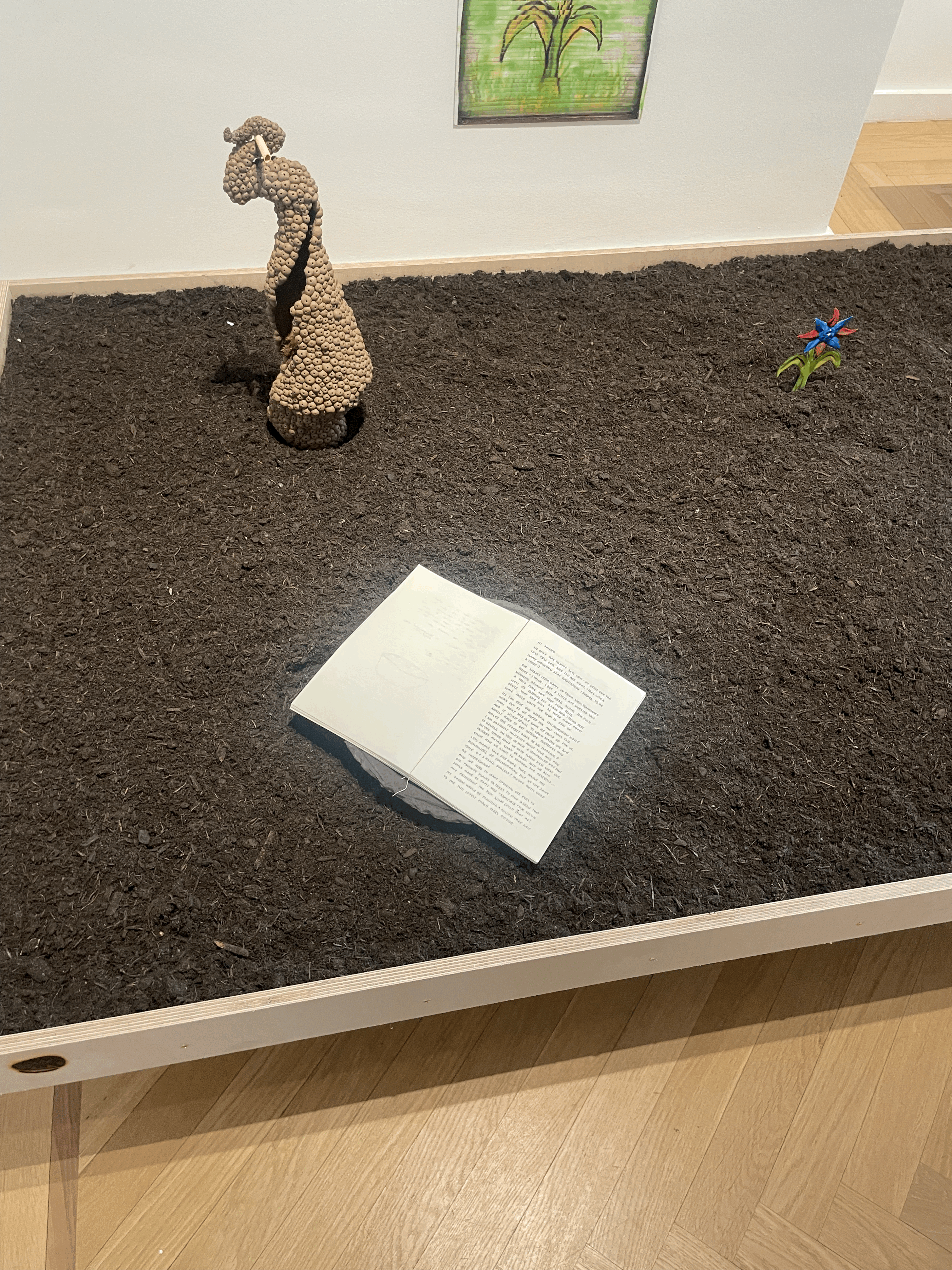 Museum Giersch 뮤지엄 기어쉬 전시 작품 중 하나 흙 위에 책과 작은 조각품이 놓여 있음