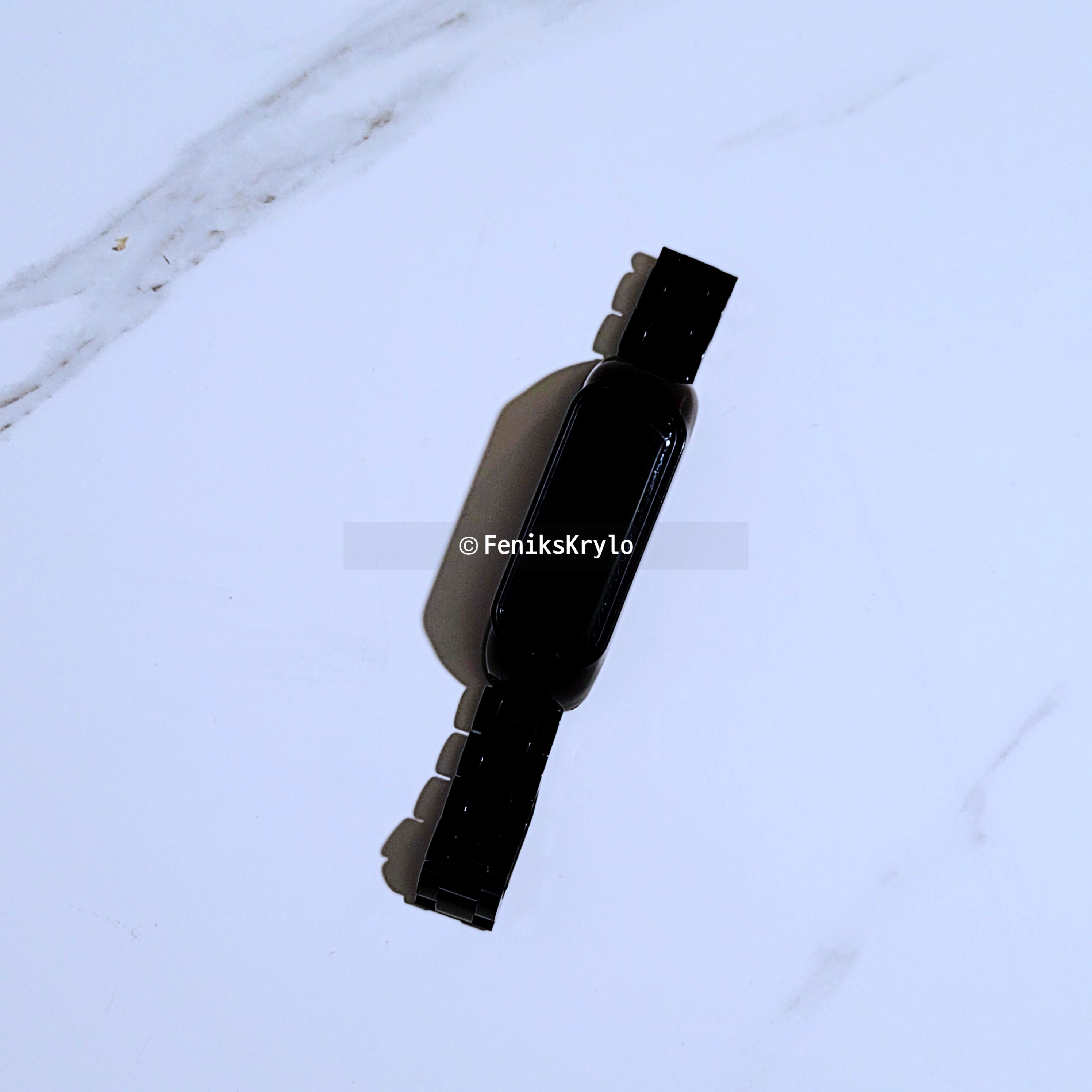 블랙-메탈-체인-스트랩을-채결한-갤럭시핏2가-테이블-위에-놓여있다.