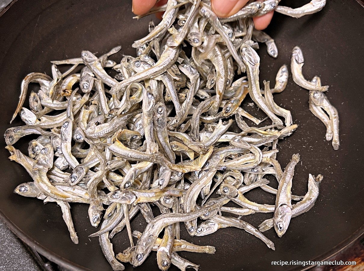 달궈진 팬에 중간 크기 마른 멸치를 덖는 사진