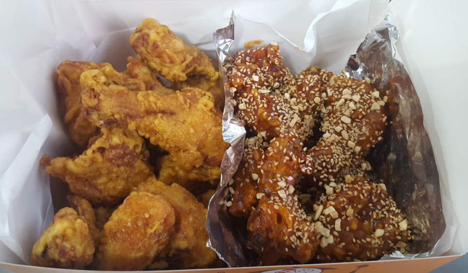 양념과후라이드치킨이 한 상자안에 먹음직스럽게 담겨있다.