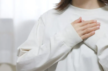 가슴에 손을 얹는 여성