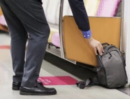 구석에-놓여진-가방을-구두를-신은-남자가-줍는-모습