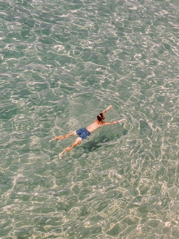 요시고 사진전 '끝나지 않은 여행' 대표 이미지, 감성적인 바다 수영 장면