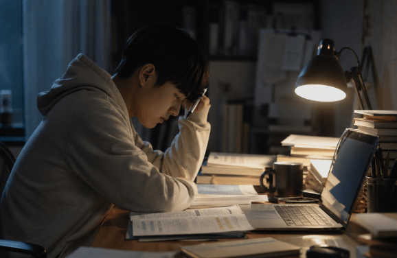 밤 늦게까지 책상 앞에서 공부하는 학생